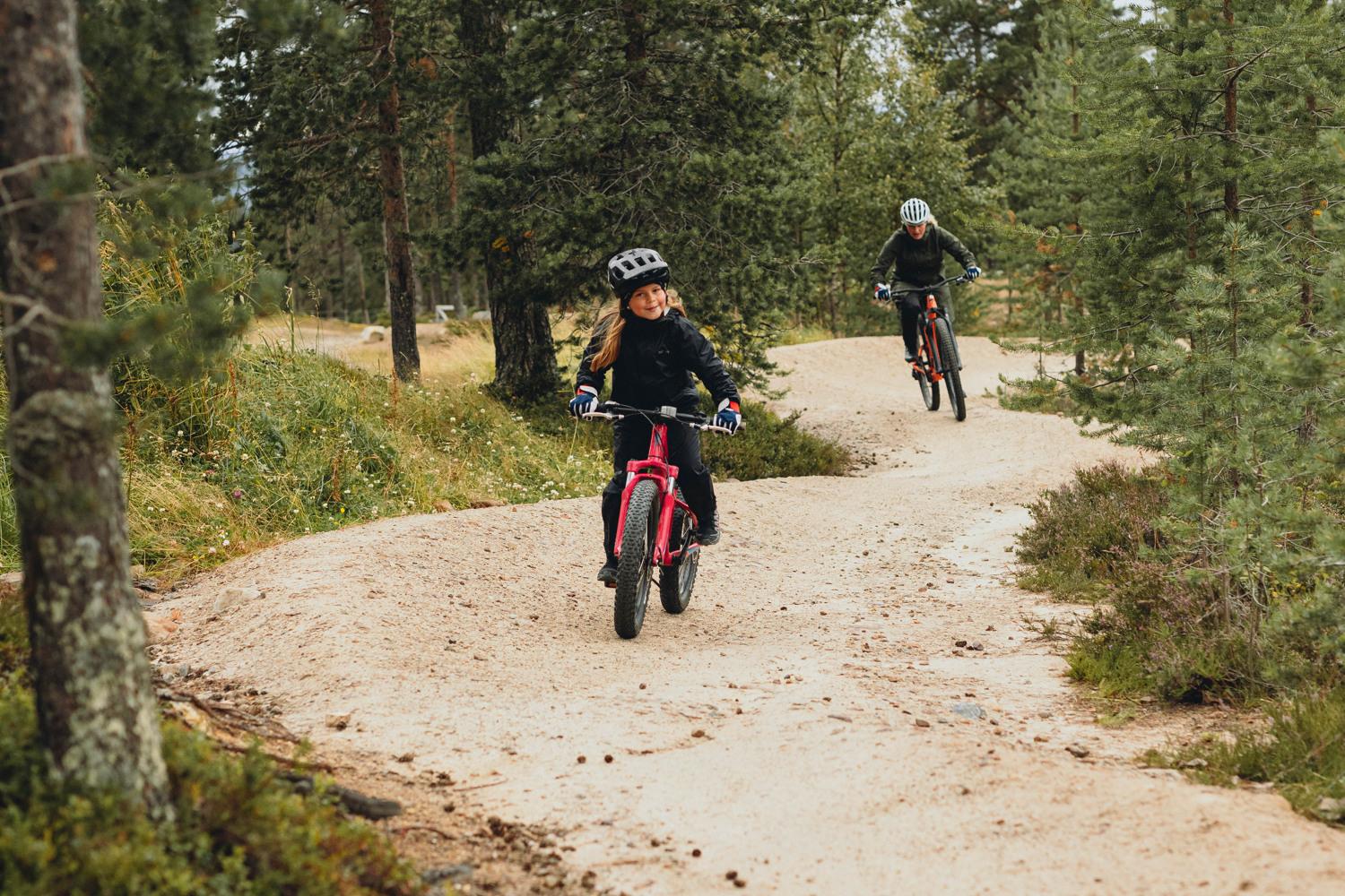 Två barn som cyklar på Idre Fjäll.