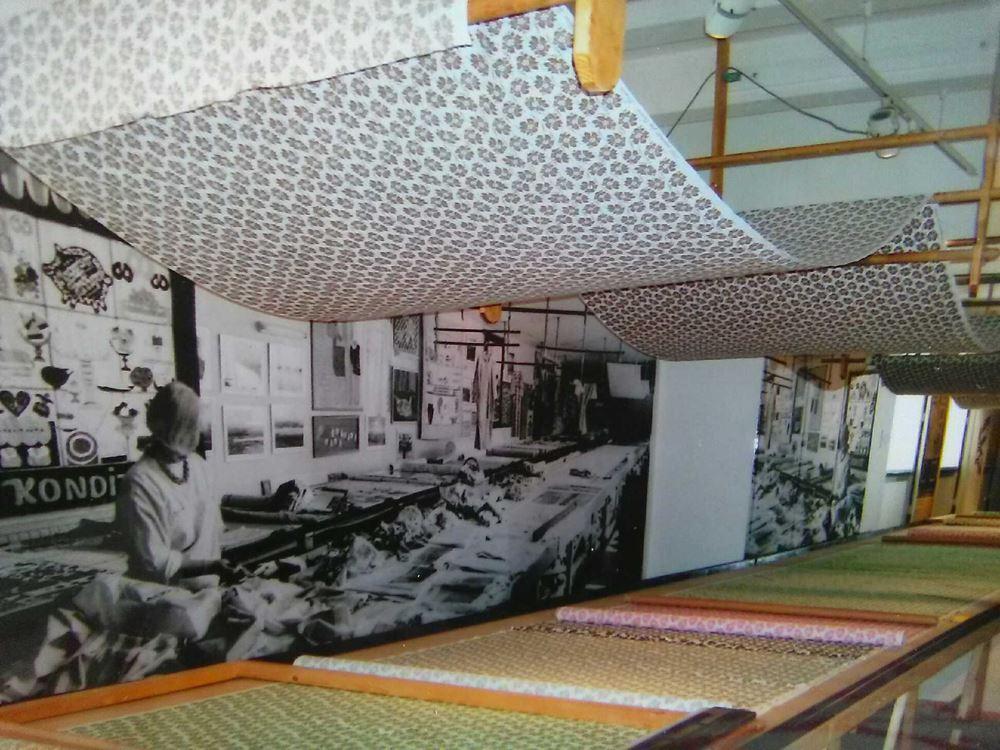 Photo wall that shows what it looked like in the studio in the past, row of fabrics, fabrics in the ceiling.