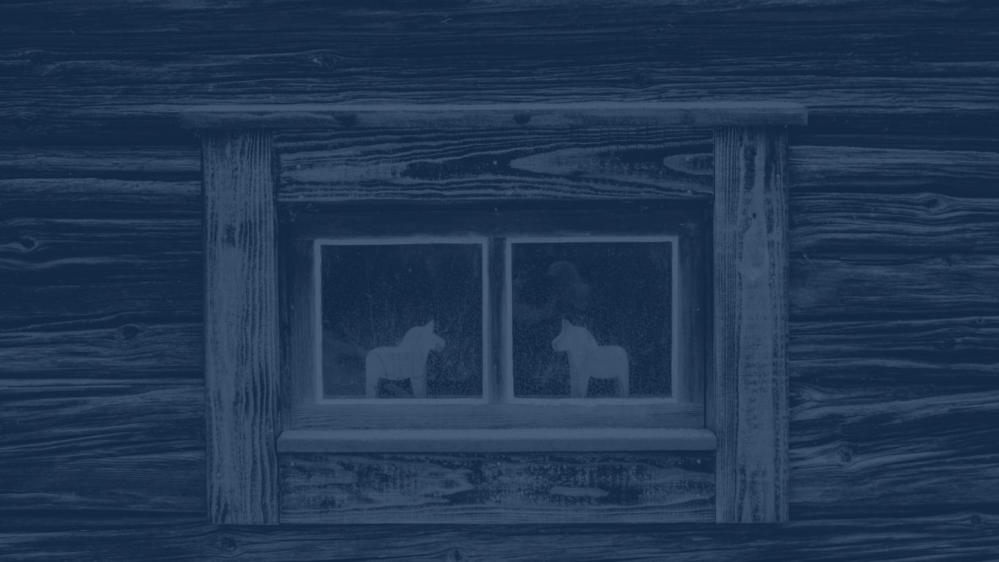 Två dalahästar i ett fönster.