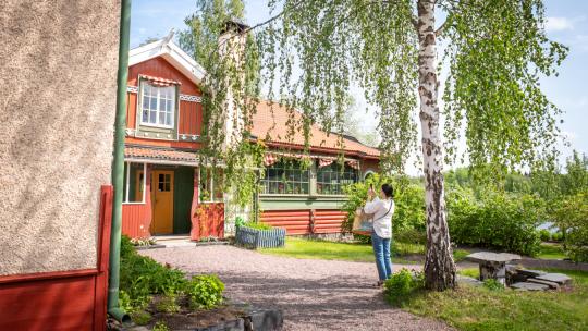 Person fotograferar entrén till Carl Larsson-gården i Sundborn.